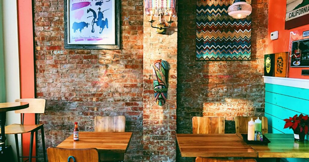 indoor restaurant with brick wall and wood tables.