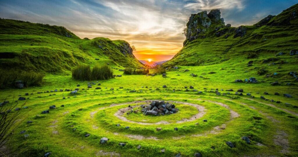 sunrise over green spiral and green mountains.